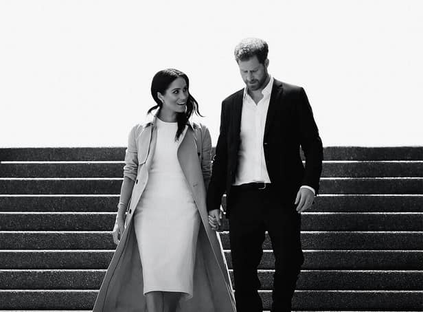 <p>A black and white image of Meghan Markle and Prince Harry walking down a flight of stairs together, hand in hand and smiling (Credit: Netflix) </p>