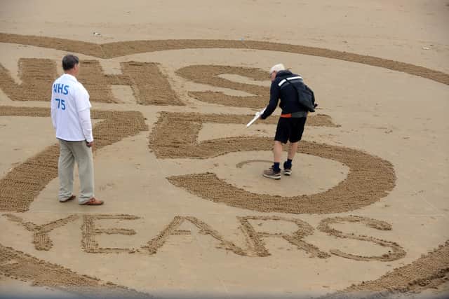 Artist Jed McCormack creating the giant heart on Seaburn beach.
