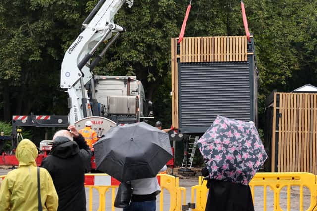 On-lookers brave the rain to watch part of Roker Park's new café being lowered into position