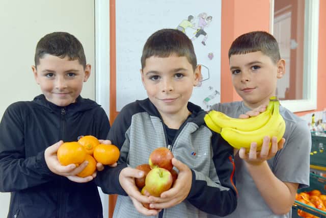 Triplets Oliver, Owen and Oscar, 8, with some of the healthy fruit they get to eat.