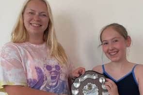 Isabella Sloens, 11, and her dance teacher Helen Tate with the trophy they won 23 years apart.