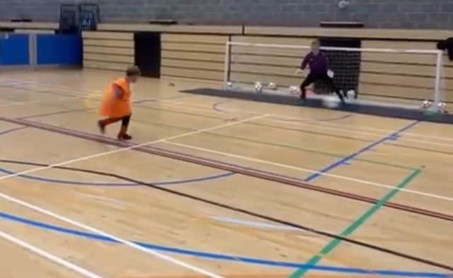 This young player scores a great goal at the summer camp.
