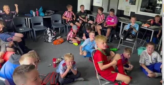 Young footballers at the Jermain Defoe soccer camp, watching the World Cup semi-final.