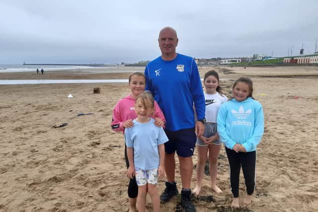Peter Curtis with beach camp participants Emily Don, 12, Evelyn Chapman, 6, Sienna Holden, 9, and Callie Lane, 9.