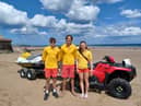 RNLI lifeguards Ben Mcmann (left), Sam Irwin (centre) and Abby Cass (right) in front of an RNLI rescue watercraft. Photo Credit: Toni Carr.