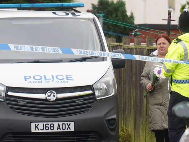 A woman arrives with floral tributes after a 54-year-old man died after he was savaged by what police believe was an XL bully on Maple Terrace in Shiney Row