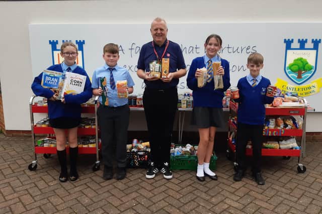 Salvation Army community manager, Graham Wharton, gratefully accepts the donation of food from Castletown Primary School head boy and girl, Daisy Ferguson and Jack Mitchell, and deputy head boy and girl, Niall Kerry and Evie Lynne.
