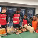 Dan Neil and Aji Alese dish out some Caribbean food to the youngsters. 