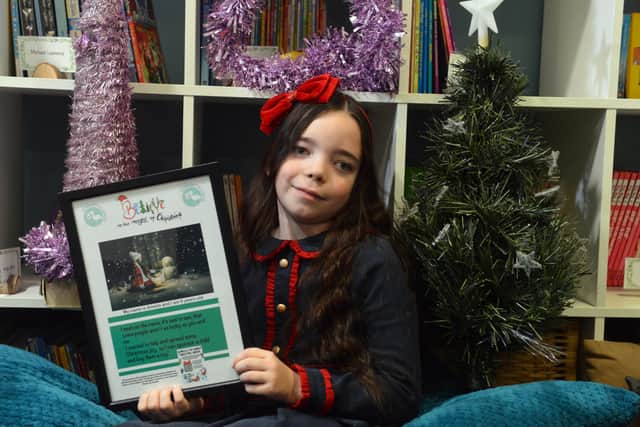 Amelia Lucas with a poster advertising her Christmas bracelet fundraiser.