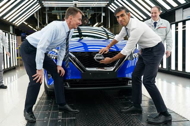 Prime Minister Rishi Sunak and Chancellor of the Exchequer Jeremy Hunt attach a Nissan badge to a car as they visit the car manufacturer Nissan on November 24, 2023 in Sunderland, England. The Prime Minister and Chancellor visit the Japanese car manufacturer as they announce they will be building three new electric car models at its plant in Sunderland as part of a £2bn investment. (Photo by Ian Forsyth/Getty Images)
