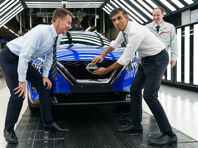 Prime Minister Rishi Sunak and Chancellor of the Exchequer Jeremy Hunt attach a Nissan badge to a car as they visit the car manufacturer Nissan on November 24, 2023 in Sunderland, England. The Prime Minister and Chancellor visit the Japanese car manufacturer as they announce they will be building three new electric car models at its plant in Sunderland as part of a £2bn investment. (Photo by Ian Forsyth/Getty Images)