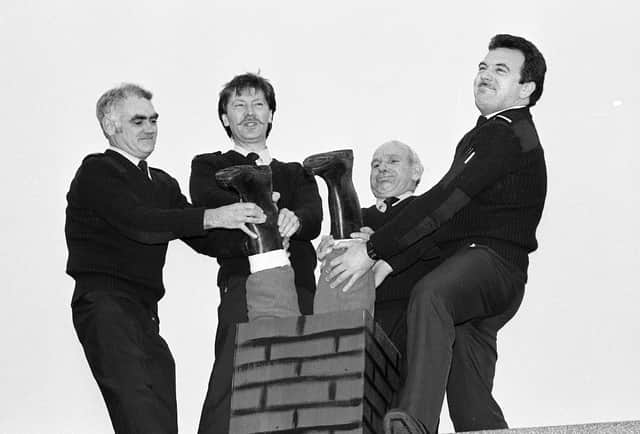 Ambulancemen try to free Santa from the chimney at Washington ambulance station in Concorde. Left to right are Bob Shaw, Peter Lawson, Jim Walker and Bill Parkin.