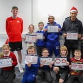 Jewison Bennette and Mason Burstow show off their football designs with children from St Mary's Catholic Primary School.