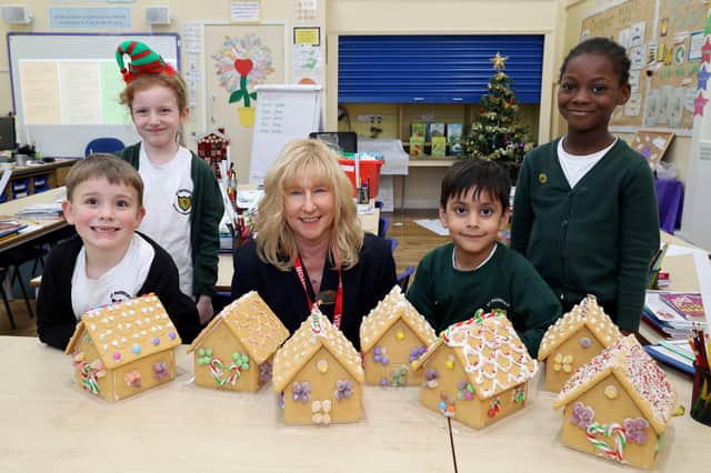 Bellway Sales Advisor Barbara Kettlewell beside more gingerbread houses made by students at St Patrick’s Primary  
 