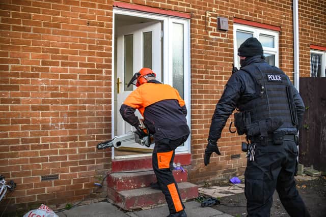 Police officers carrying out a raid on a property in Thorney Close.