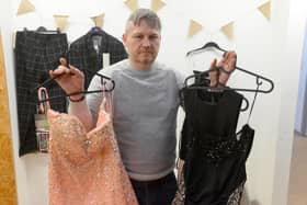 Lee Nicholson with some of the donated prom dresses and suits.