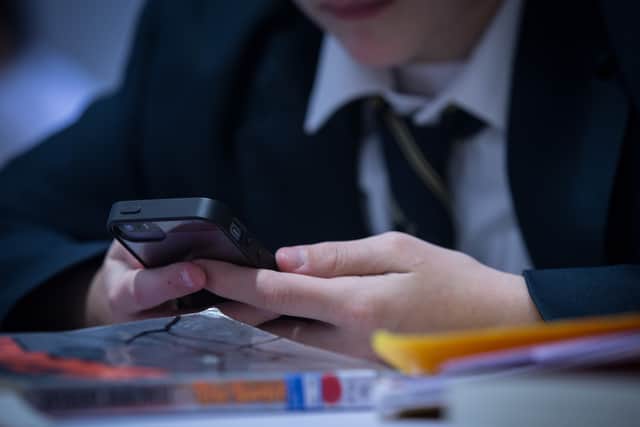 A pupil using their mobile phone in school.