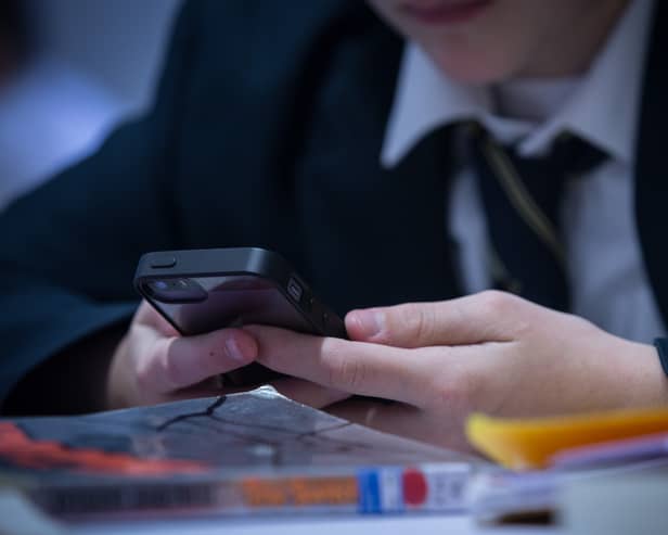 A pupil using their mobile phone in school. (Credit: Getty Images)