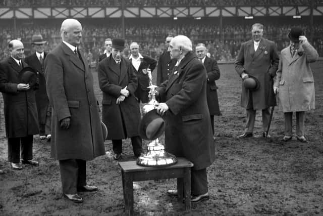 C E Sutcliffe, acting president of the Football League (right), prepares to hand over the league championship trophy to Sunderland chairman Sir Walter Raine.
