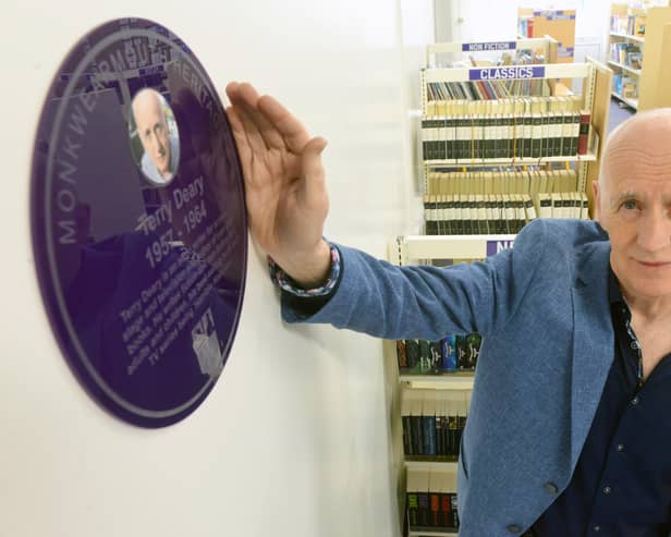 Terry Deary unveils his plaque in the school's library.