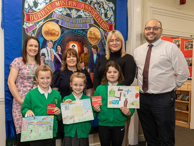 Pupils Nina Hoggarth, Darcie Hoggarth and Tiana Graham with their winning designs alongside headteacher Alison McDonough, MP Mary Kelly Foy and Avant Homes representative Frank Teggarty.