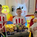William Fletcher, centre, with brothers Jacob, right, and Henry, left, and their trolley of chocolate gifts. Submitted picture.