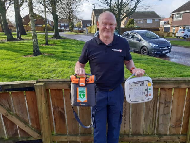 Neville Harris with two life saving defibrillators.