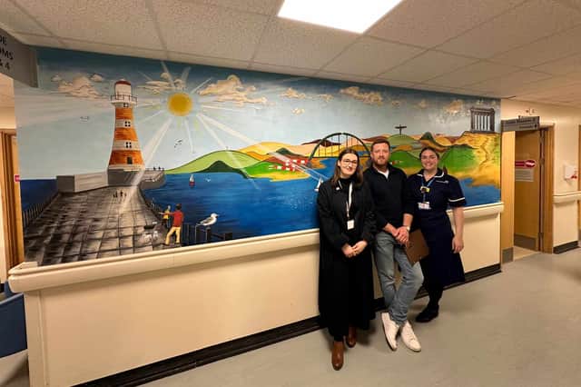 Sara Hoxhaj, of Alzheimer's Research UK, Neil Gibbins and E56 Ward Manager Sam Carmichael with his mural. Submitted picture.