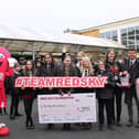 Southmoor Academy pupils handing over a cheque to the Red Sky Foundation's founder, Sergio Petrucci.