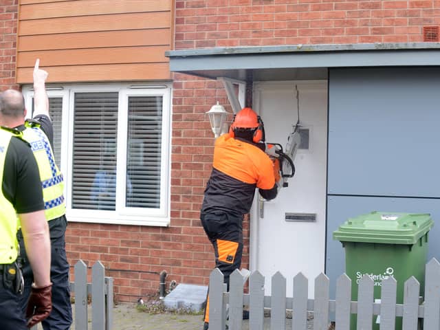 Police use a chainsaw to enter an address in Washington