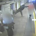 Man shoves stranger onto tracks as train arrives at platform.