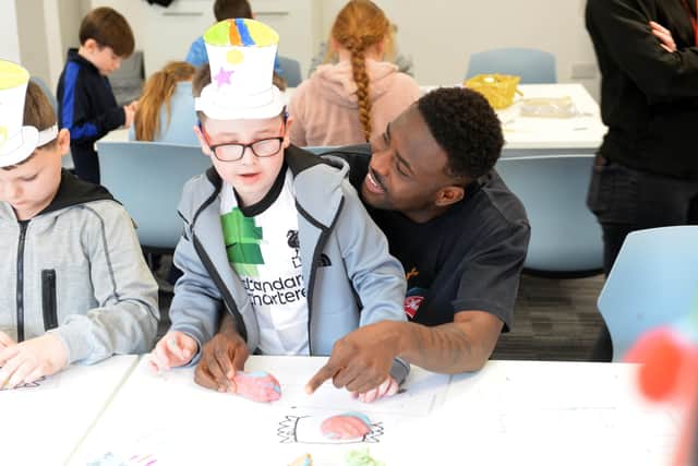 Salis Abdul Samed helping a child with his work.