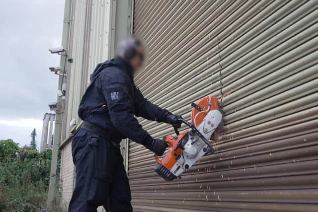 Police officers gain entry to the property.