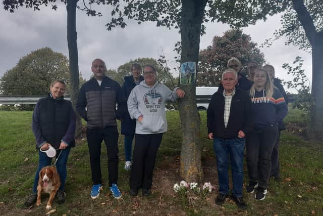 Jonathan and members of the local community next to Buddy's memorial plaque.