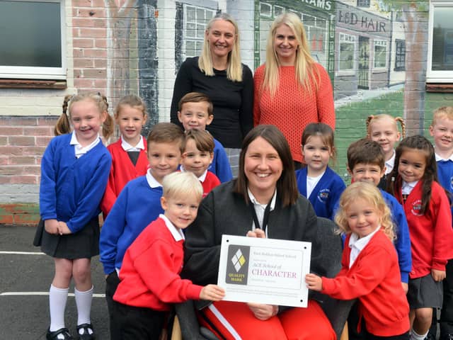 East Boldon Infants School headteacher Lisa Holt (middle) with staff and pupils as they celebrate receiving the prestigious ACE School of Character Quality Mark Award.