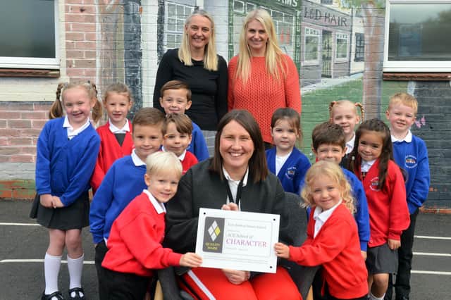 East Boldon Infants School headteacher Lisa Holt (middle) with staff and pupils as they celebrate receiving the prestigious ACE School of Character Quality Mark Award.