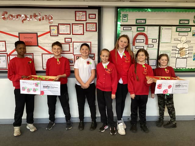 The Year 6 Poppy Club children with the poppies they made.