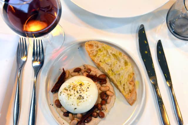A burrata dish from the starters menu, served with a smooth bean puree, a semidried tomato salad and homemade Tuscan bread.