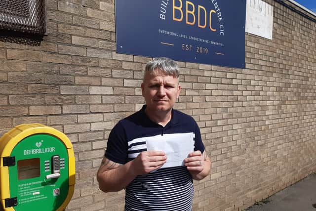 Building Blocks Day Centre CIC founder Lee Nicholson with the court notice claiming £25,000 over donated prom garments.