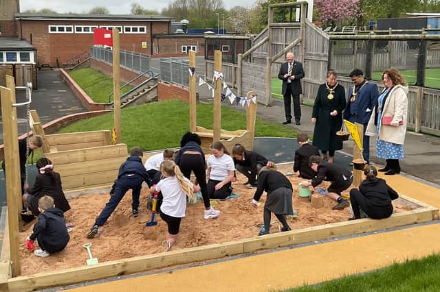 Children enjoy making use of the new sand pit.