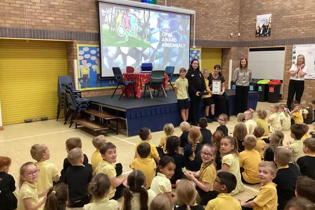 Pupils and staff receiving the award in the OPAL assembly.