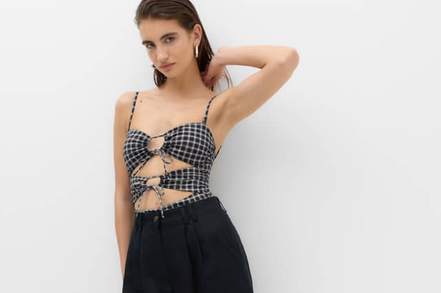 The M&S Checked Cut Out Bandeau Swimsuit combines a modern cut-out design with a flattering bandeau silhouette
