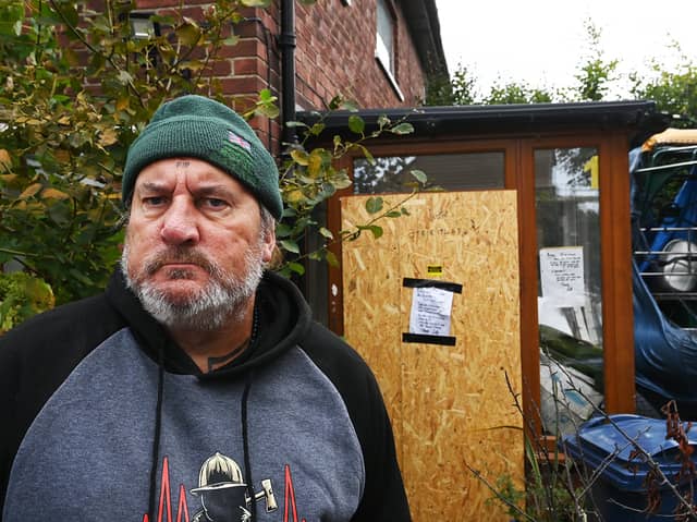 Scott Lumsdon, 58, outside of his boarded up back door.
