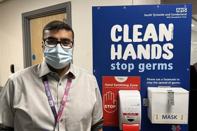 Dr Shaz Wahid at a hospital hygiene stations.