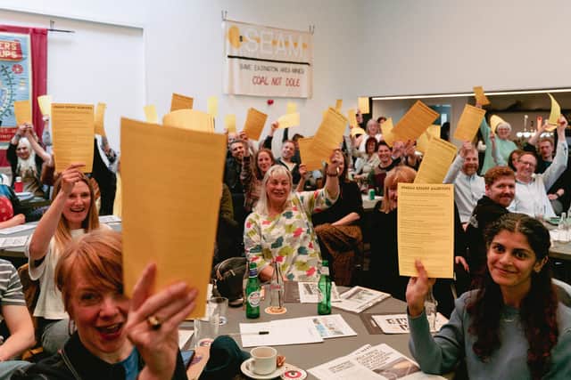 The enthusiastic audience at the launch of the Durham Energy Manifesto, wave their copies of the document.