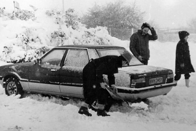 Teachers from Outwood Grange school work to free a car which has been trapped in snow in the 1980s.