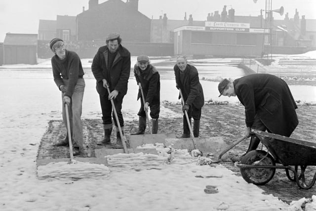 A team of workers clear the pitch at Wakefield Trinity's stadium in March 1979.
