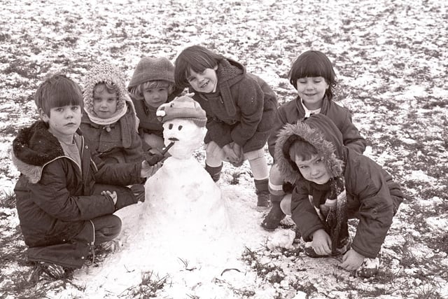 And a group of children proudly show off their snowman after a day in the snow in South Kirkby in 1985.