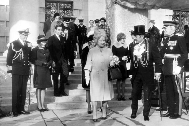 On the steps of the Civic Hall, on the left, is Captain A.D. Cassidy, who commanded the Ark Royal. To the right of the Queen Mother is the Lord Mayor of Leeds, Alderman Kenneth Travis Davison, wearing his chain of office.
