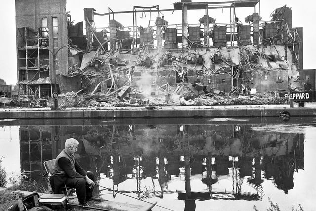 A lone angler is undisturbed as across the canal Westwood Power Station is demolished on Thursday 7th of September 1989 following the cooling towers demolition on January 15th of that year.